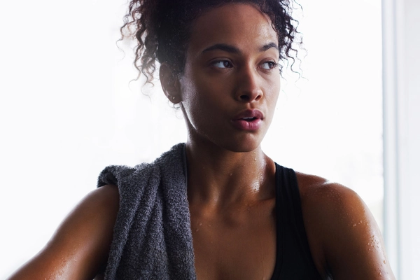 image shows a women after the gym using hypochlorous acid spray on her skin